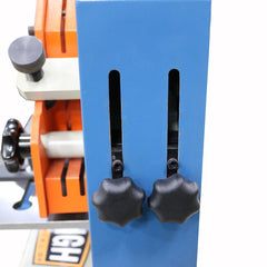 Close-up of a blue tool with black knobs on a white background