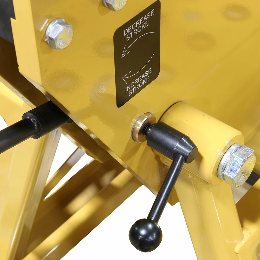 Close-up of a yellow mechanical component with control levers and a label on a white background