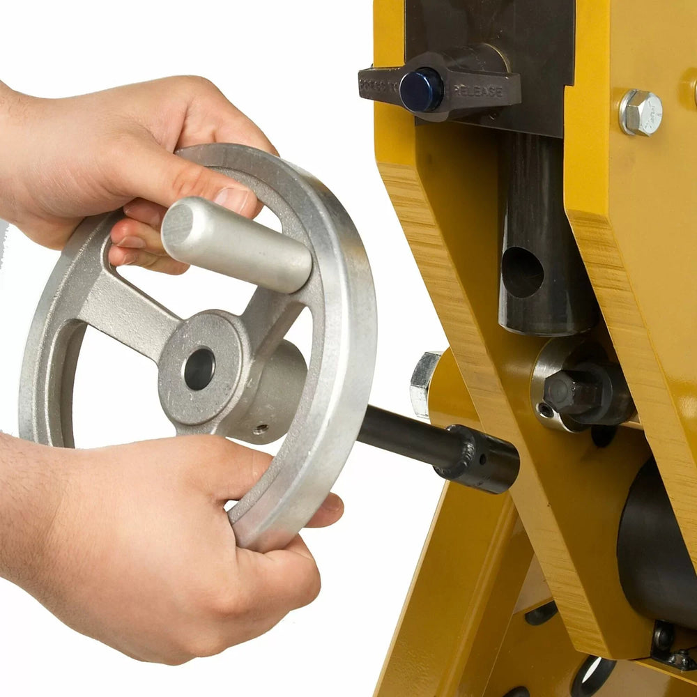 Person using a metalworking tool with a yellow machine in the background