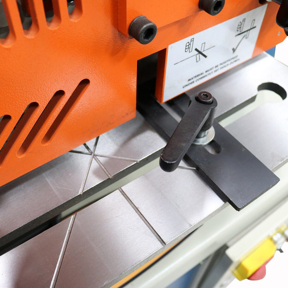 Close-up of a tile cutting machine with an orange and black design on a tiled floor.