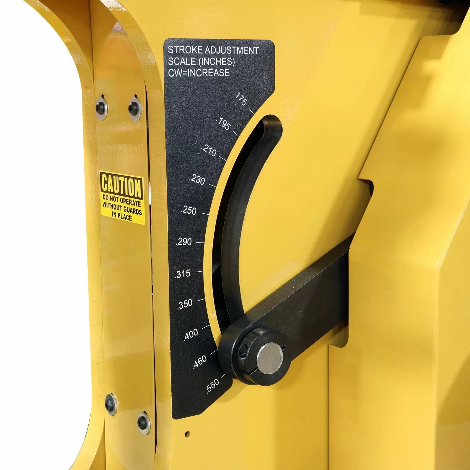 Close-up of a yellow machine with a stroke adjustment scale and warning label.