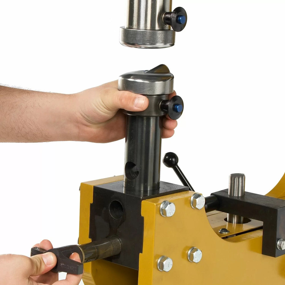 Person operating a mechanical device with a focus on hands and tool interaction.