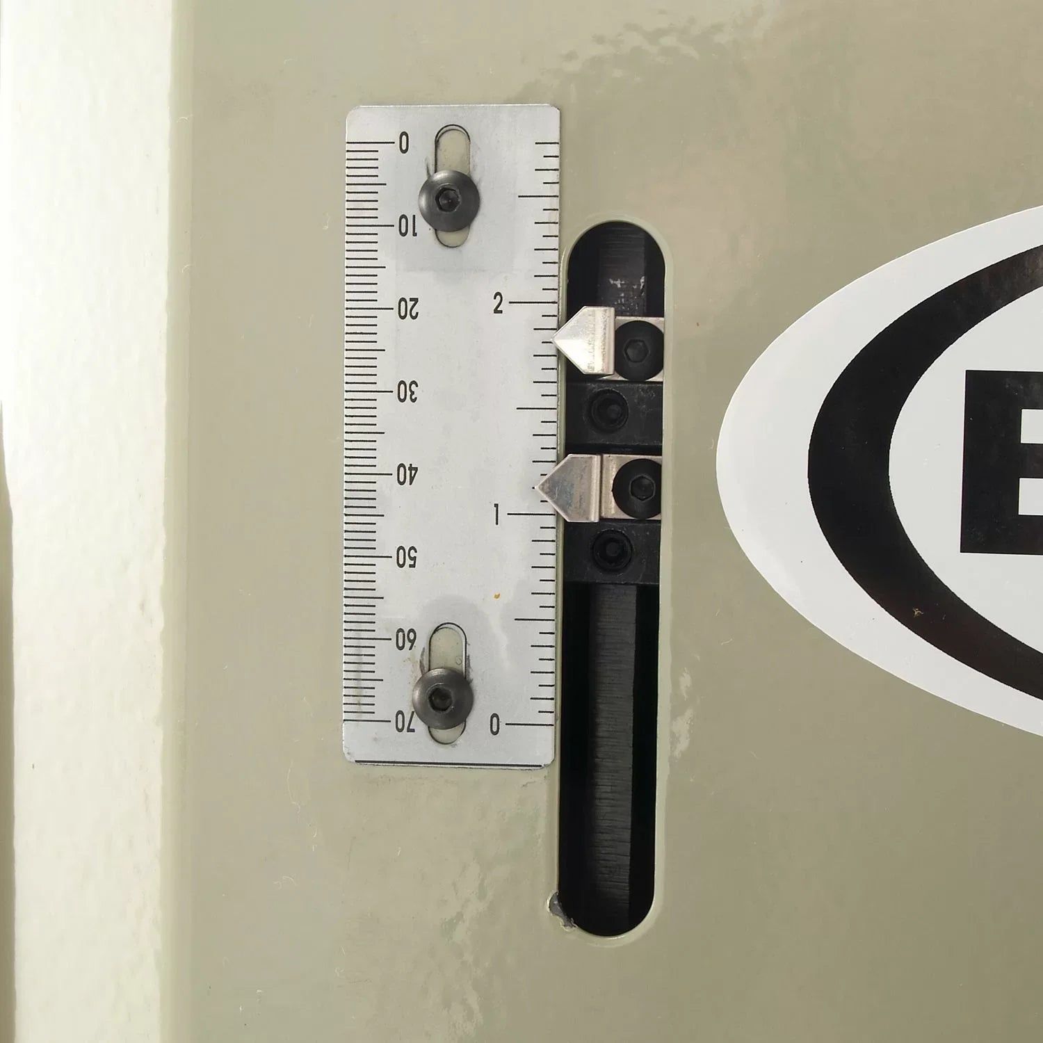 Metal ruler attached to a wall with a logo in the corner